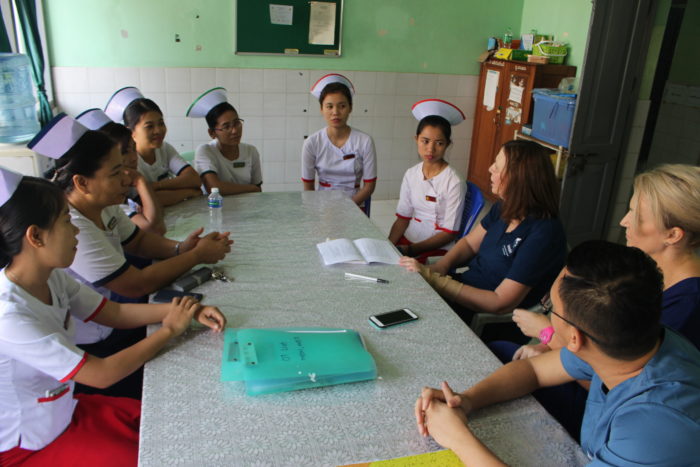 Nurses sitting around a table talking with Interplast staff and volunteers