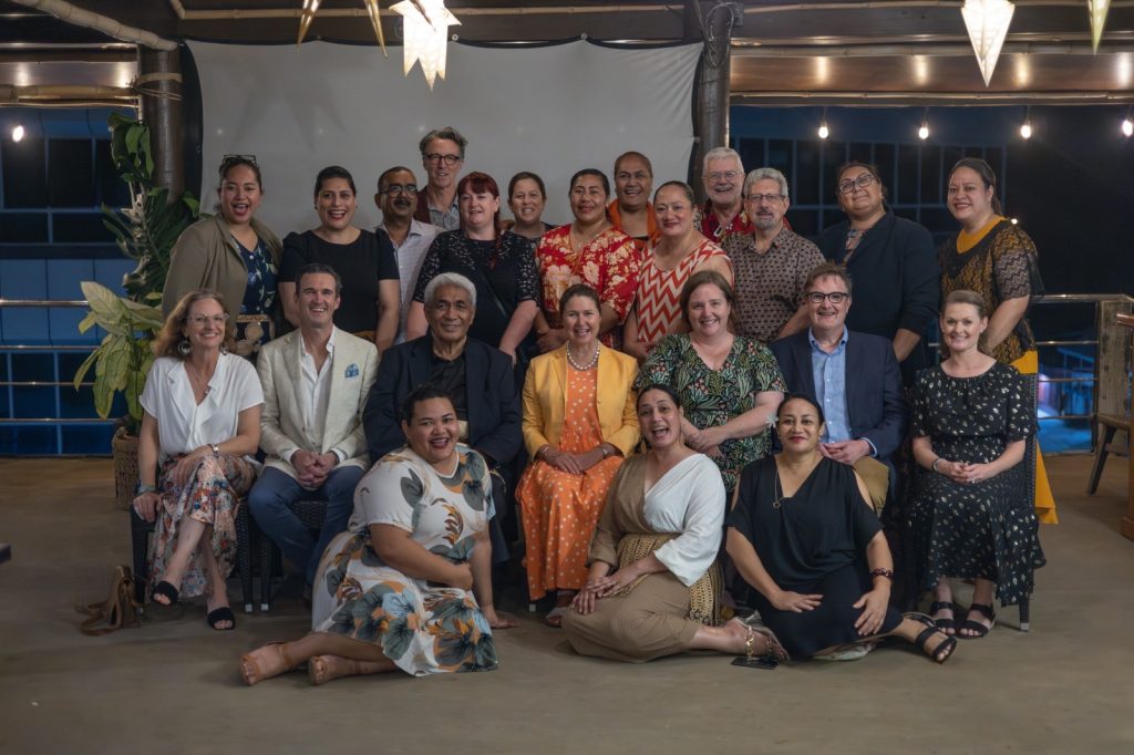 A group of 23 people, Tongans and international visitors, smile for a photo.