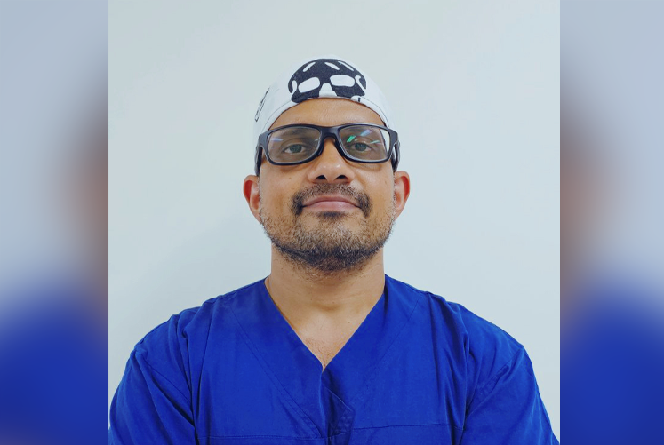 Photo of Dr Singh in scrubs and sunglasses.