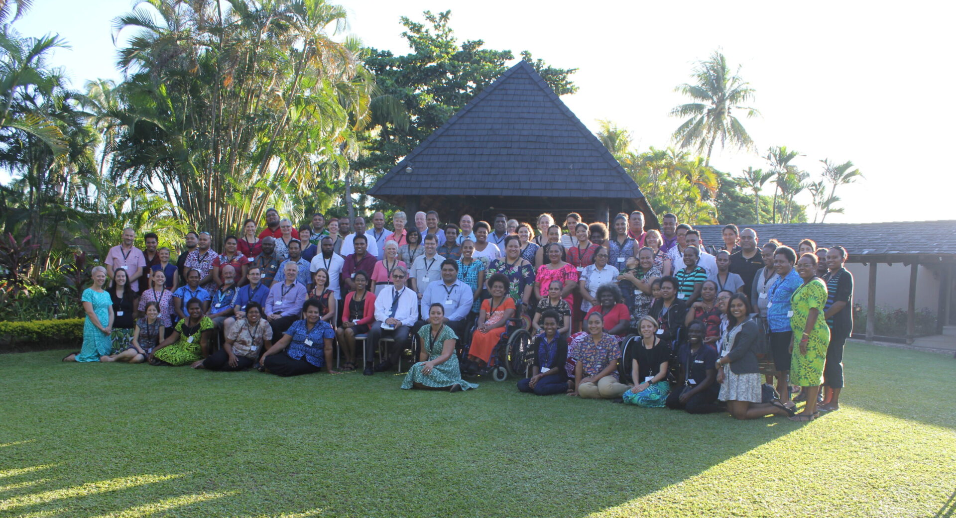 A large group of people gathered outside to take a photo.