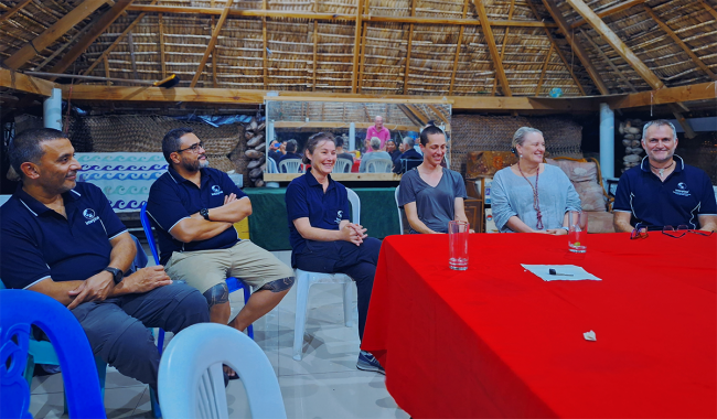 Six people wearing Interplast shirts gathered around a table.