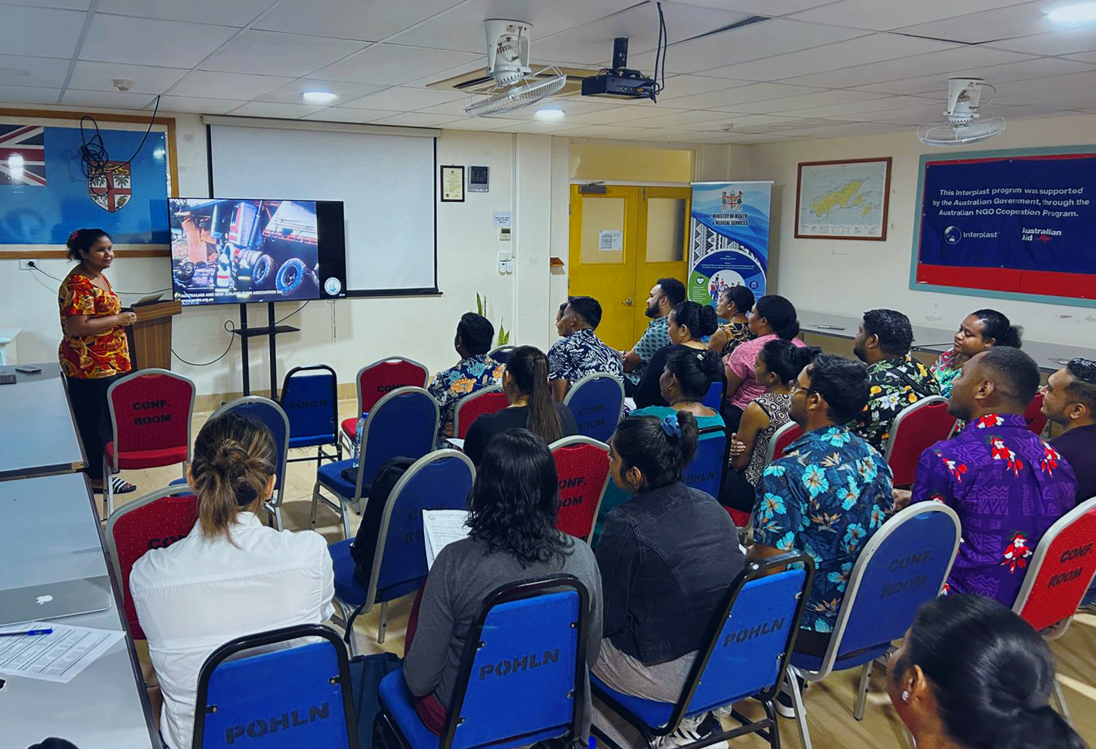 A presenter speaks to a classroom full of people.