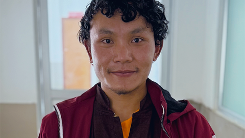 A young man smiles for the camera.