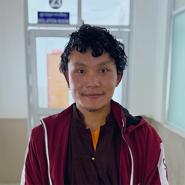 A young man smiles for the camera.